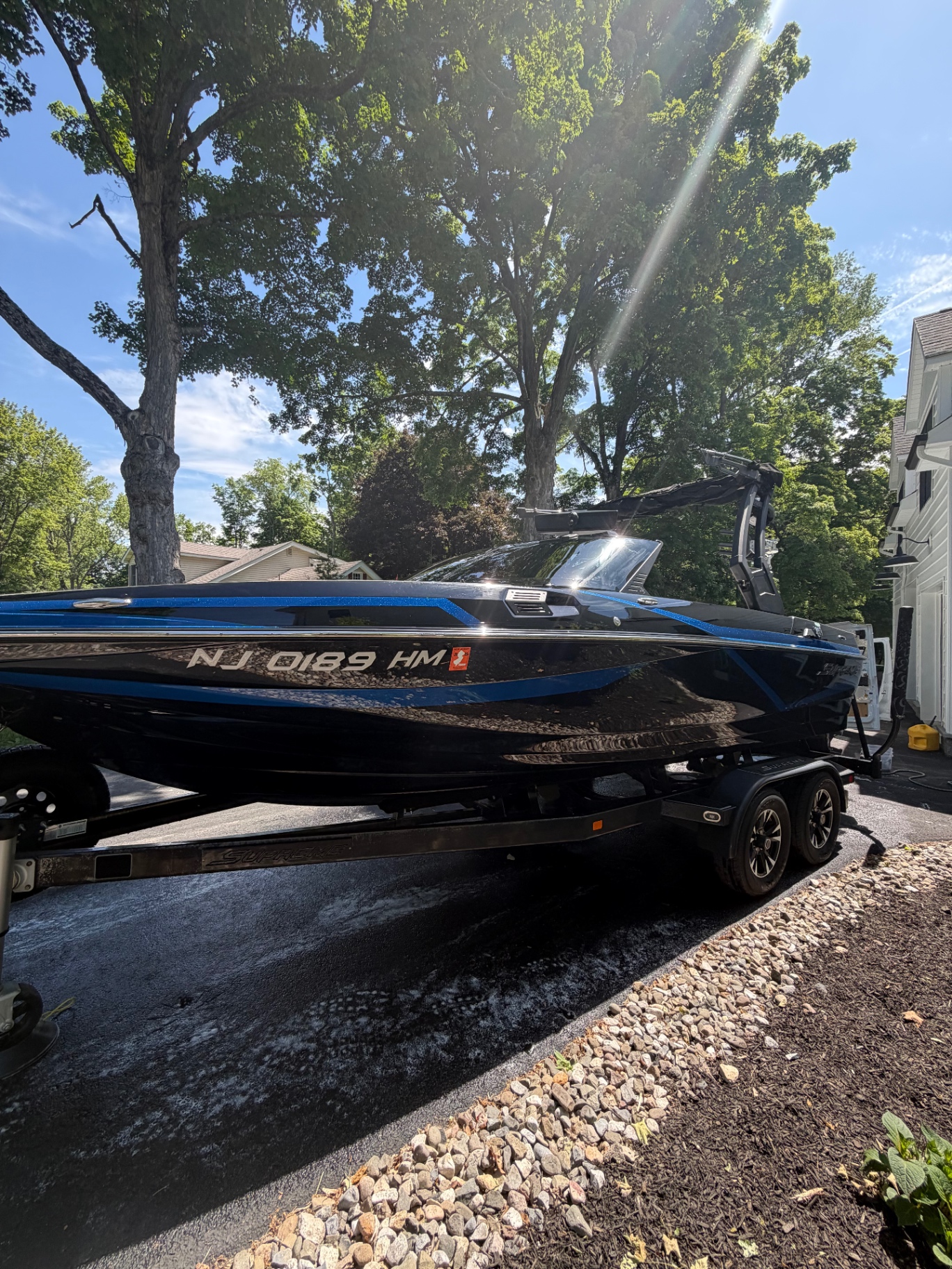 Black and blue wakeboard boat washed and polished on its trailer